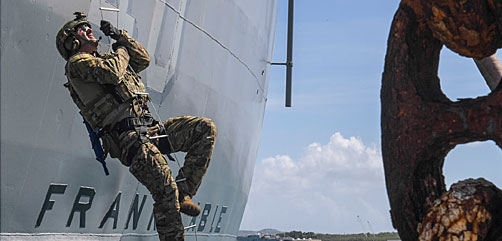 A Marine climbs a caving ladder to board the USS Frank Cable during a visit, board, search and seizure drill at Naval Base Guam, March 21, 2018. Marines and sailors conducted the training with British Royal Marines. Navy photo by Petty Officer 1st Class Cory Asato. - ALLOW IMAGES