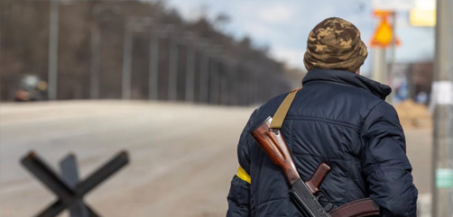Ukranian guard scans approach to border crossing.